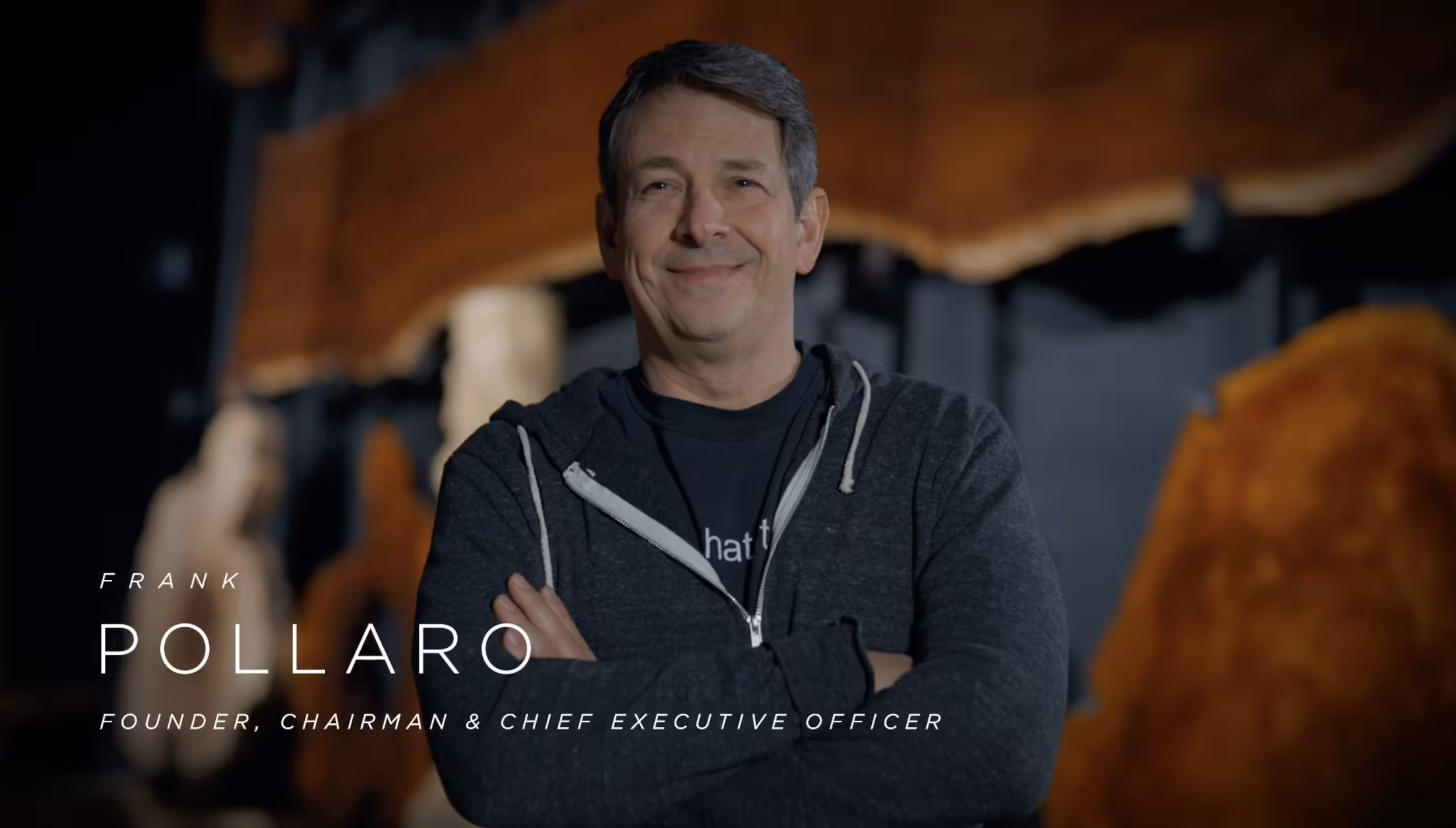 Portrait of Frank Pollaro, Founder, Chairman and Chief Executive Officer, standing with arms crossed in a woodworking workshop.